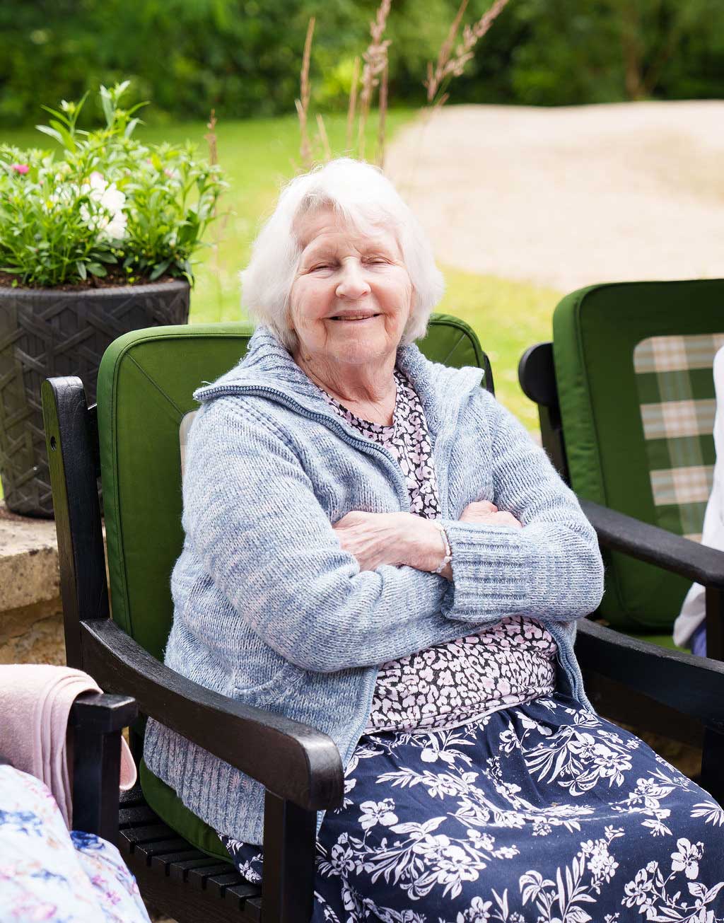 Smiling Resident Sitting in Green Garden Chair